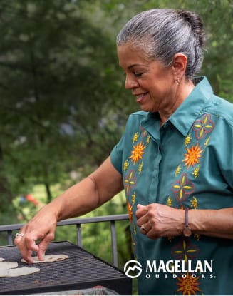 Person outdoors wearing floral apparel from the Magellan collection. Magellan Outdoors logo appears at the bottom of the image.