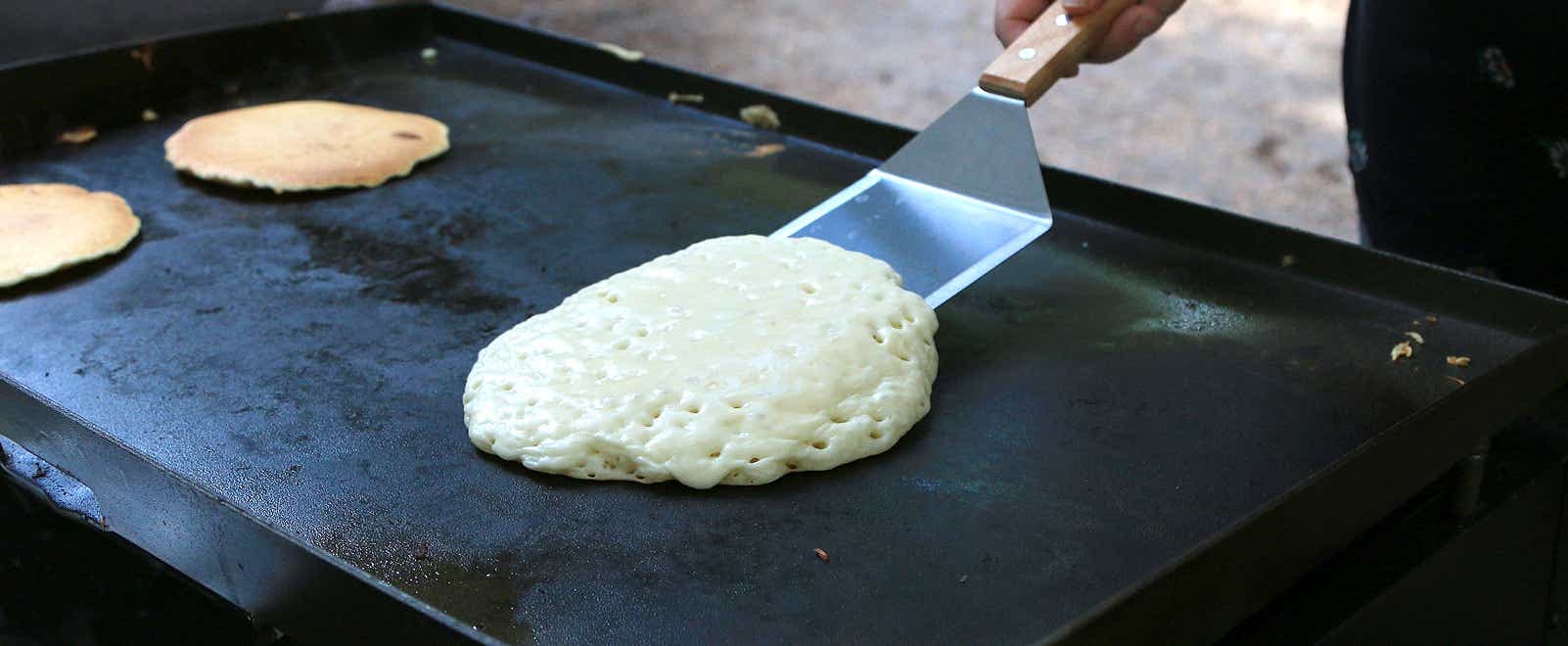 Pancakes cooking on a griddle top