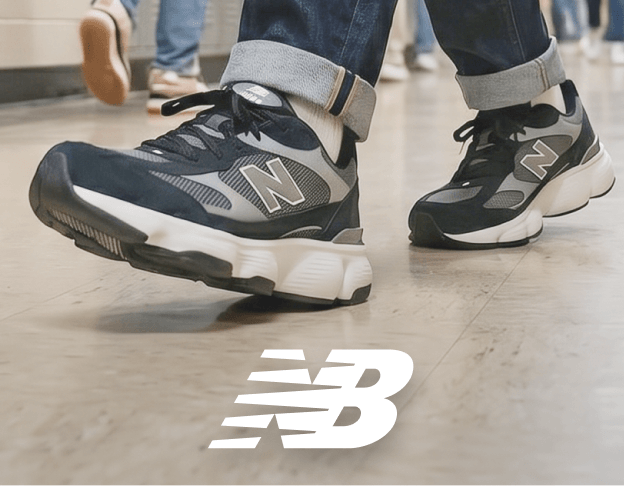 Close-up of gray and white New Balance athletic shoes on a light-colored floor.