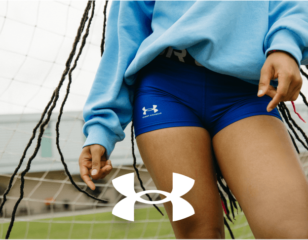 Girl in blue Under Armour athletic outfit sitting outdoors.