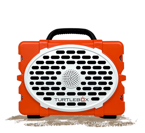 Orange Turtlebox portable speaker with black handle, white front grille, and visible Turtlebox logo displayed on a light gray background.