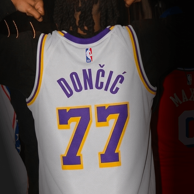 Back view of a white NBA basketball jersey with purple and gold trim showing the name DONČIĆ and the number 7.