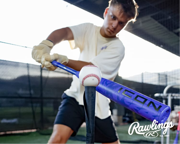 Person taking a swing at a baseball on a batting tee with a blue Rawlings Icon baseball bat at an outdoor batting cage. Rawlings logo appears in the lower-right corner.