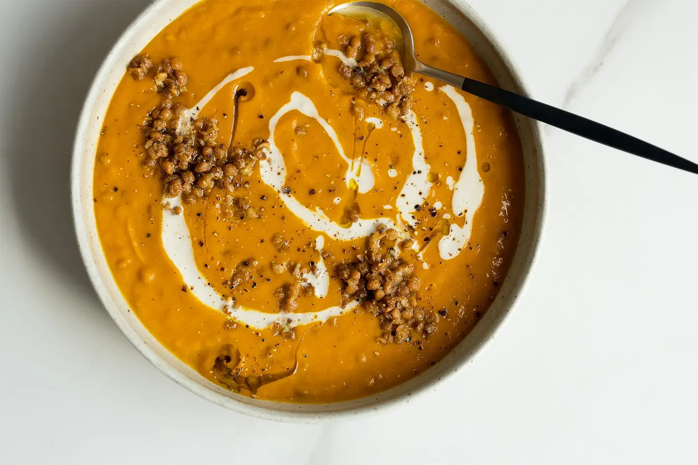 Pumpkin, sweet potato and lentil soup topped with garlicky olive oil lentils