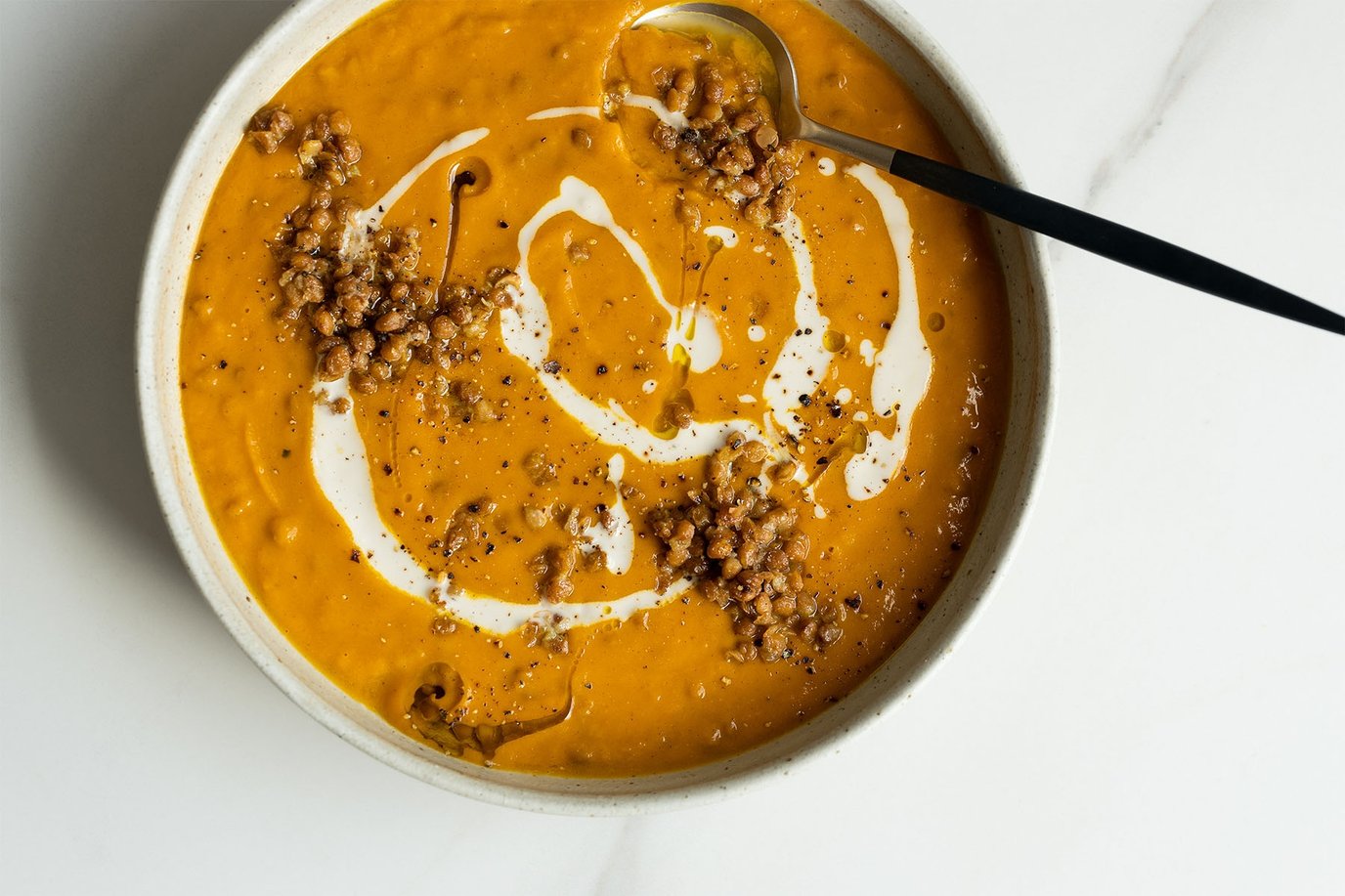 Pumpkin, sweet potato and lentil soup topped with garlicky olive oil lentils