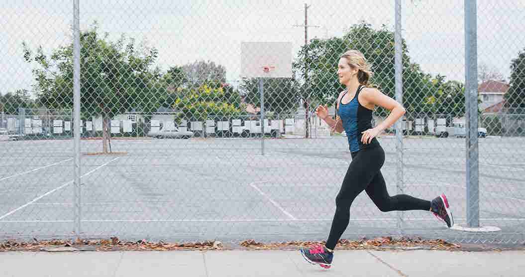 Woman jogging in front of basketball courts
