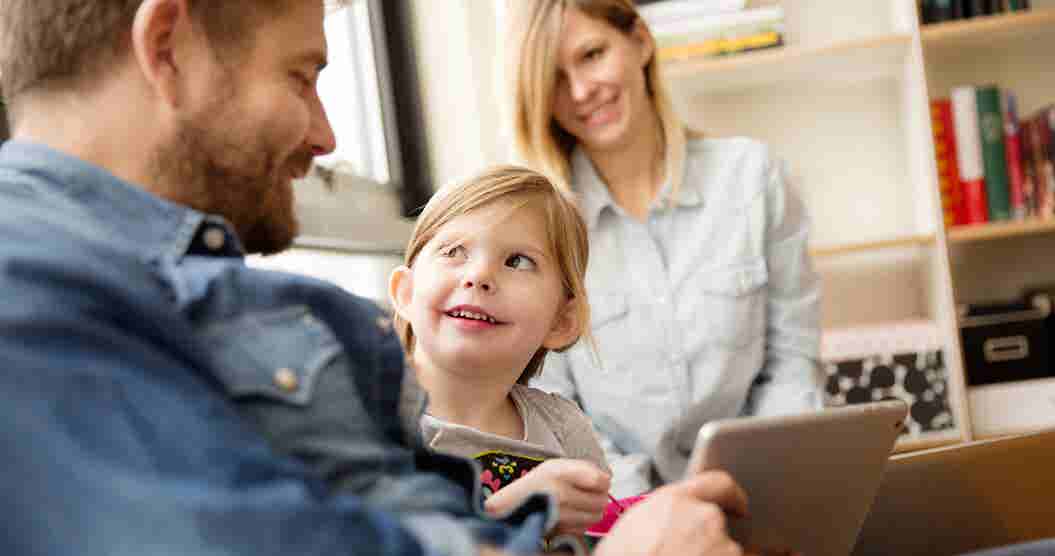 Father showing daughter tablet.