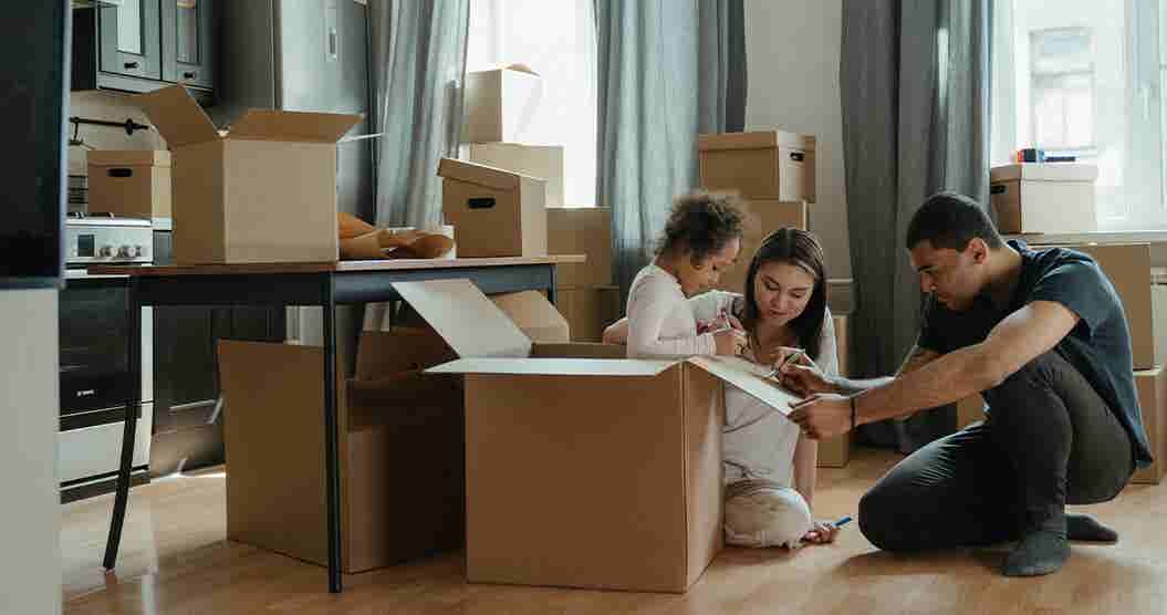 Family labeling boxes as they prepare to move.