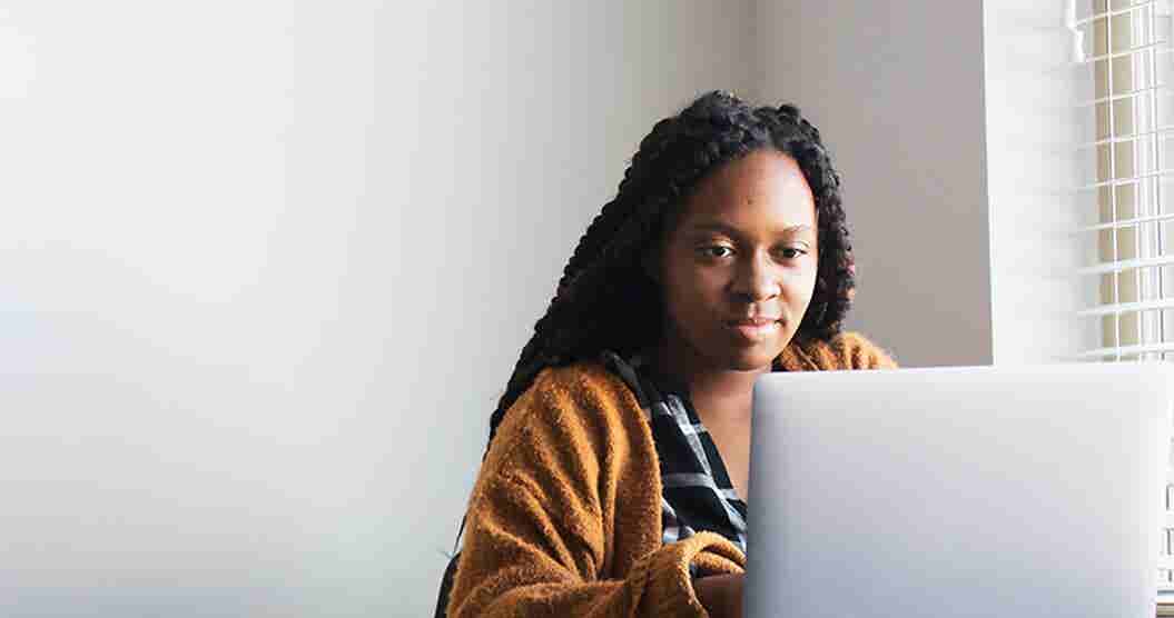 Woman researching on her laptop ways to earn money on the side.