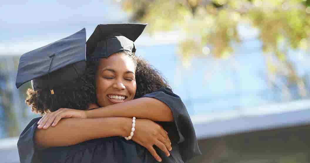 Woman hugging friend after graduating college