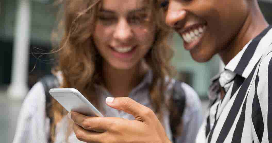 A man and woman researching what is a good credit score on their cellphone