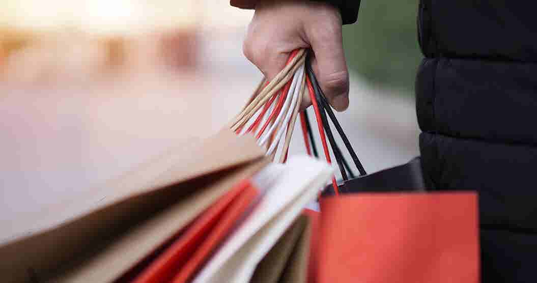 Close-up of man holding multiple shopping bags