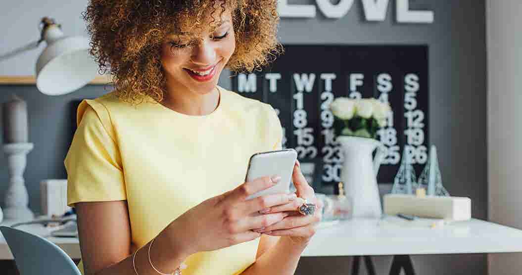 Woman on her phone reading stories of random acts of kindness