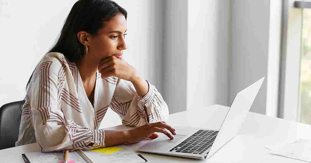 Woman using her laptop to research the pay yourself first budgeting method.