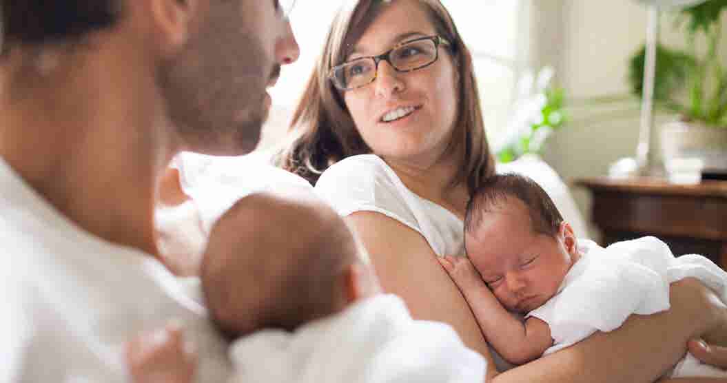 Mother and father holding newborn babies