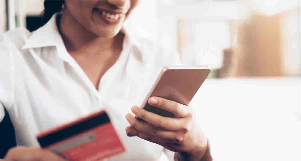 Woman using her phone to make an online purchase with a credit card