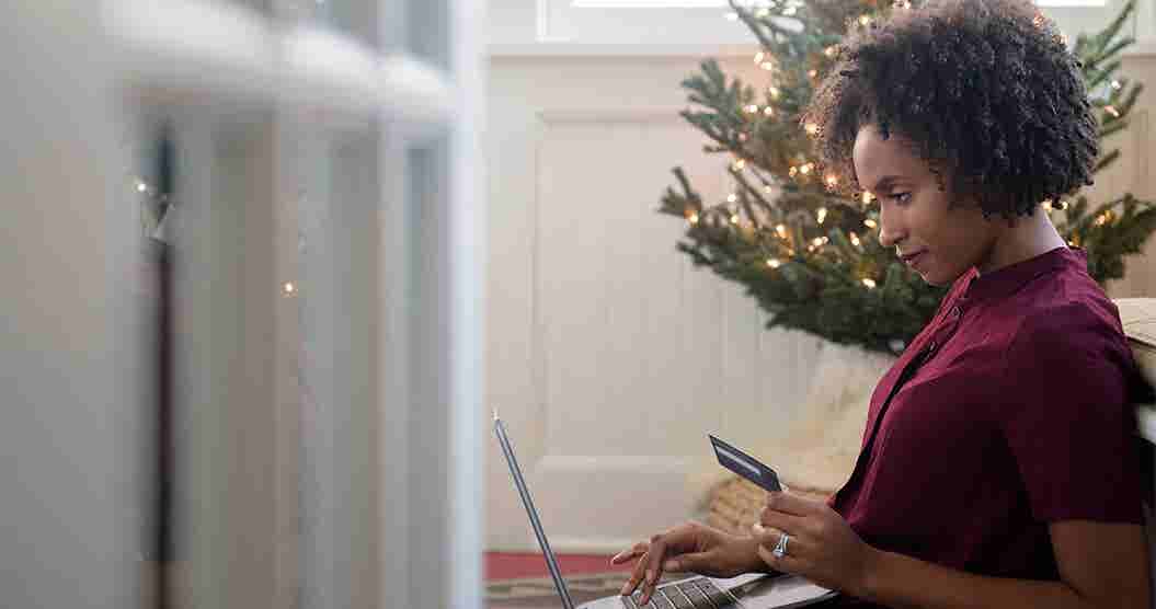 Woman sitting in front of her Christmas tree to shop online