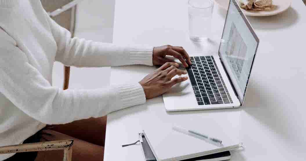 Person using a  laptop computer to research debt reduction strategies online