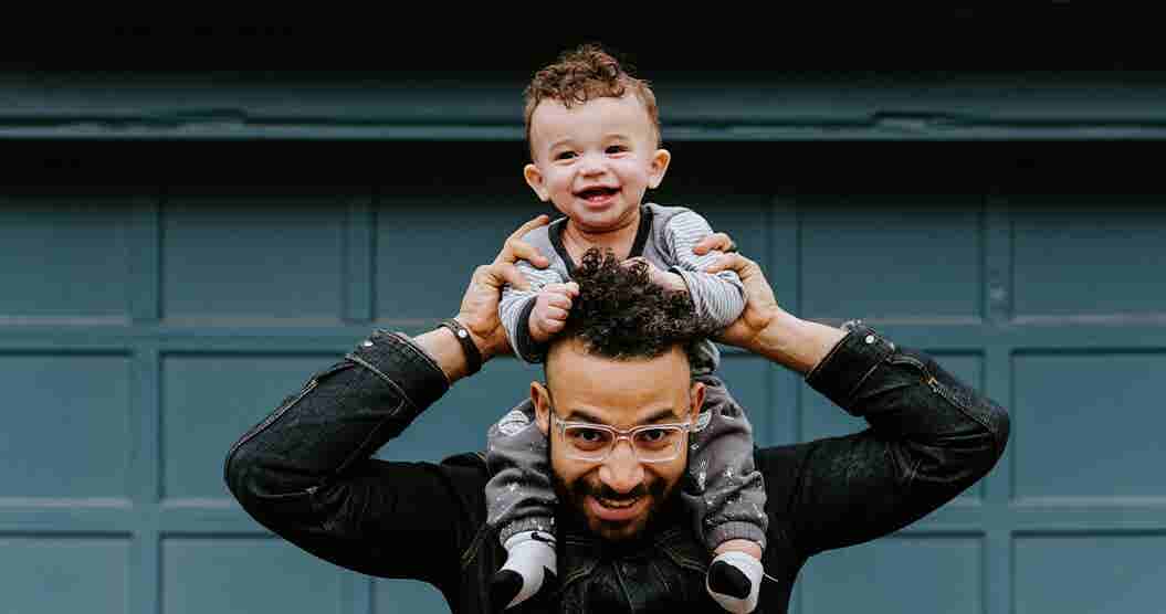 Father playing with his young son on his shoulders