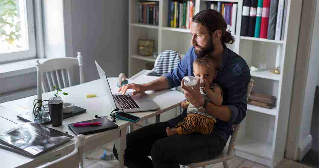 Man with baby at table in front of computer