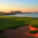 fairway and green at Yas Links with red bunkers and the sea to the right.