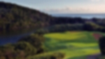Downward view of the fairway and green at Wild Coast. The river to the left of the hole guards the green as well as the sea in the background.