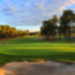 The green and flag at Pinehurst in North Carolina. The fairways are lined by trees as you approach the green.