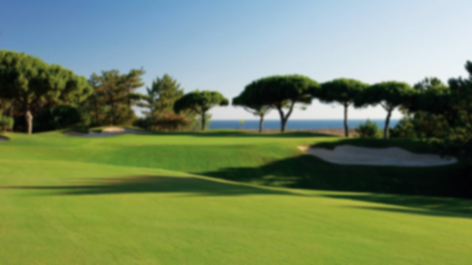 Undulating fairways in the shadows with blue skies above