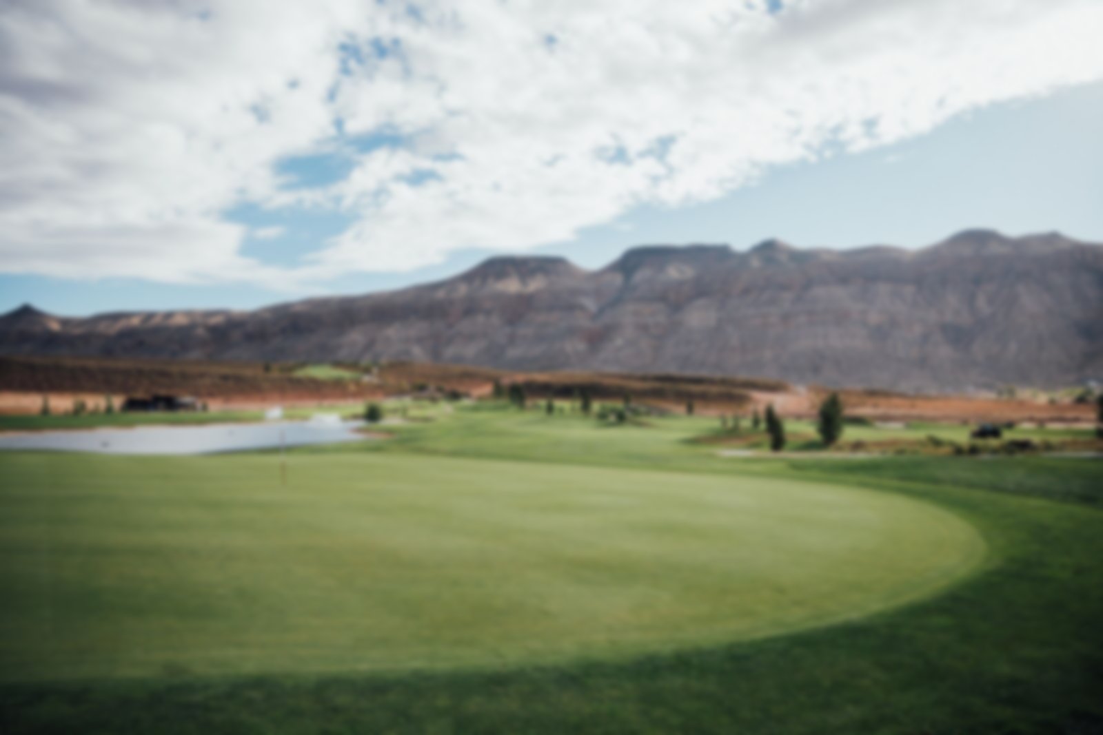 Close shot of the green with mountains in the background 