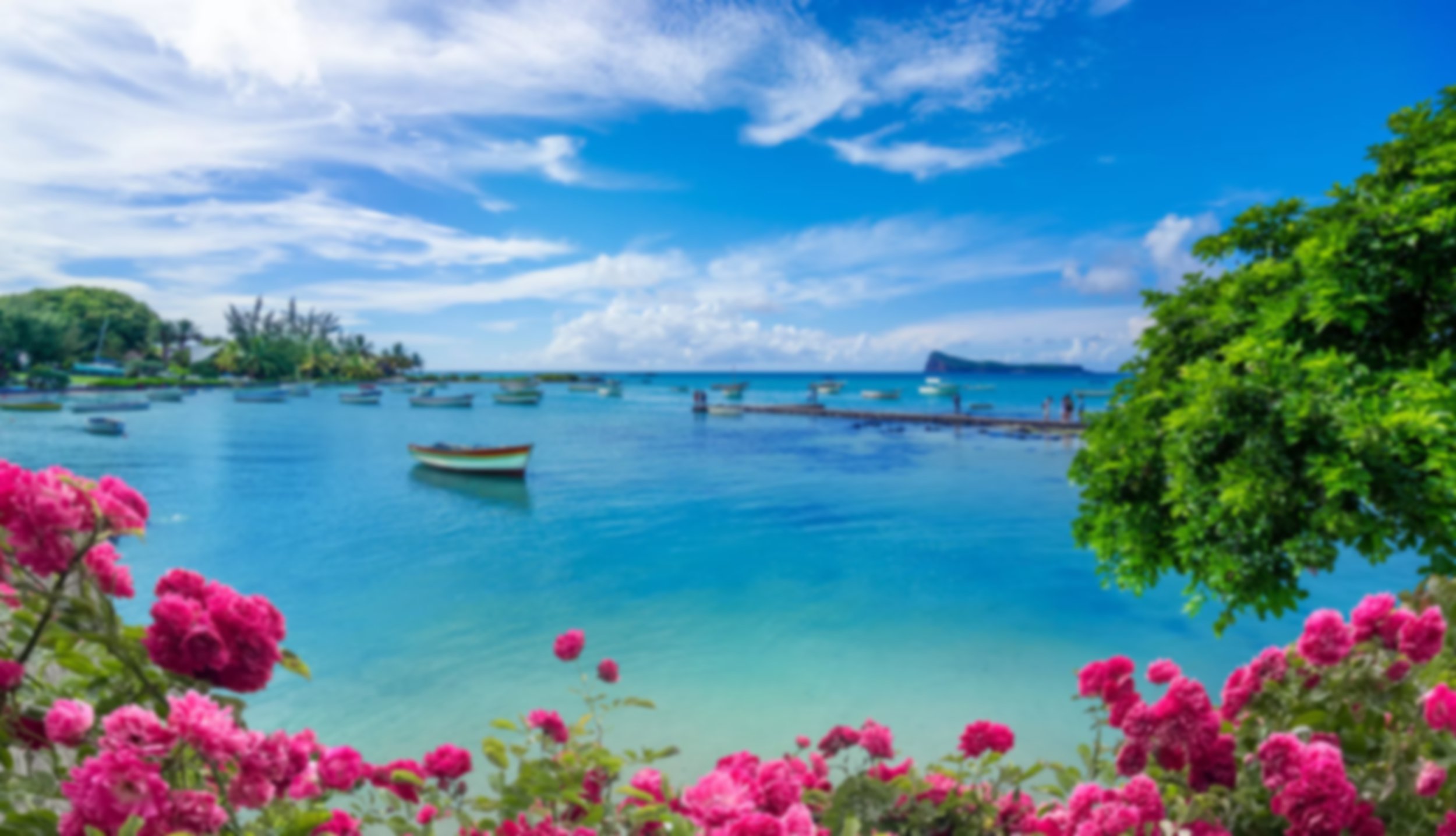 Vibrant seascape in Mauritius featuring boats on clear turquoise water framed by lush greenery and pink flowers.