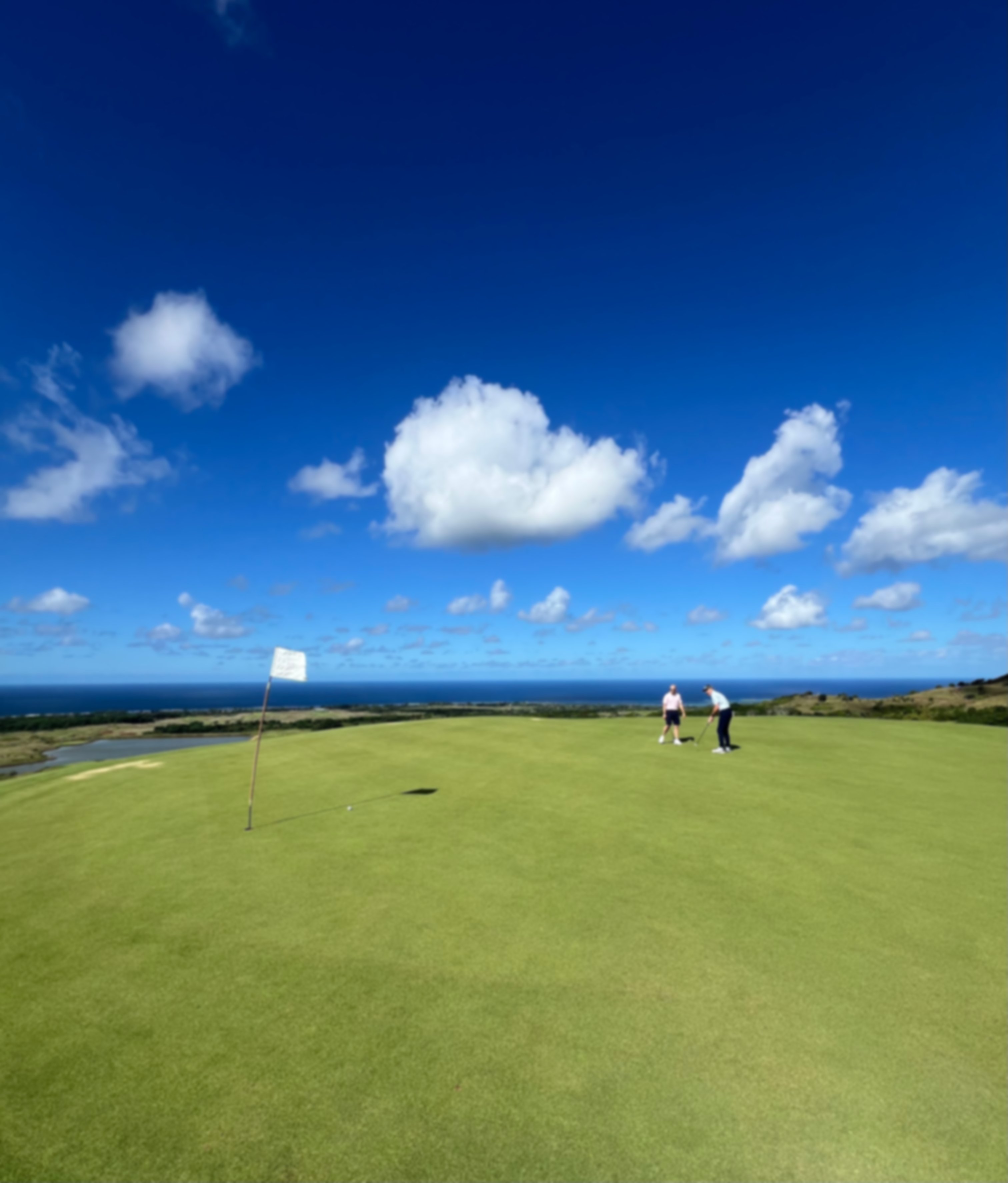 Golfers on the course under blue skies