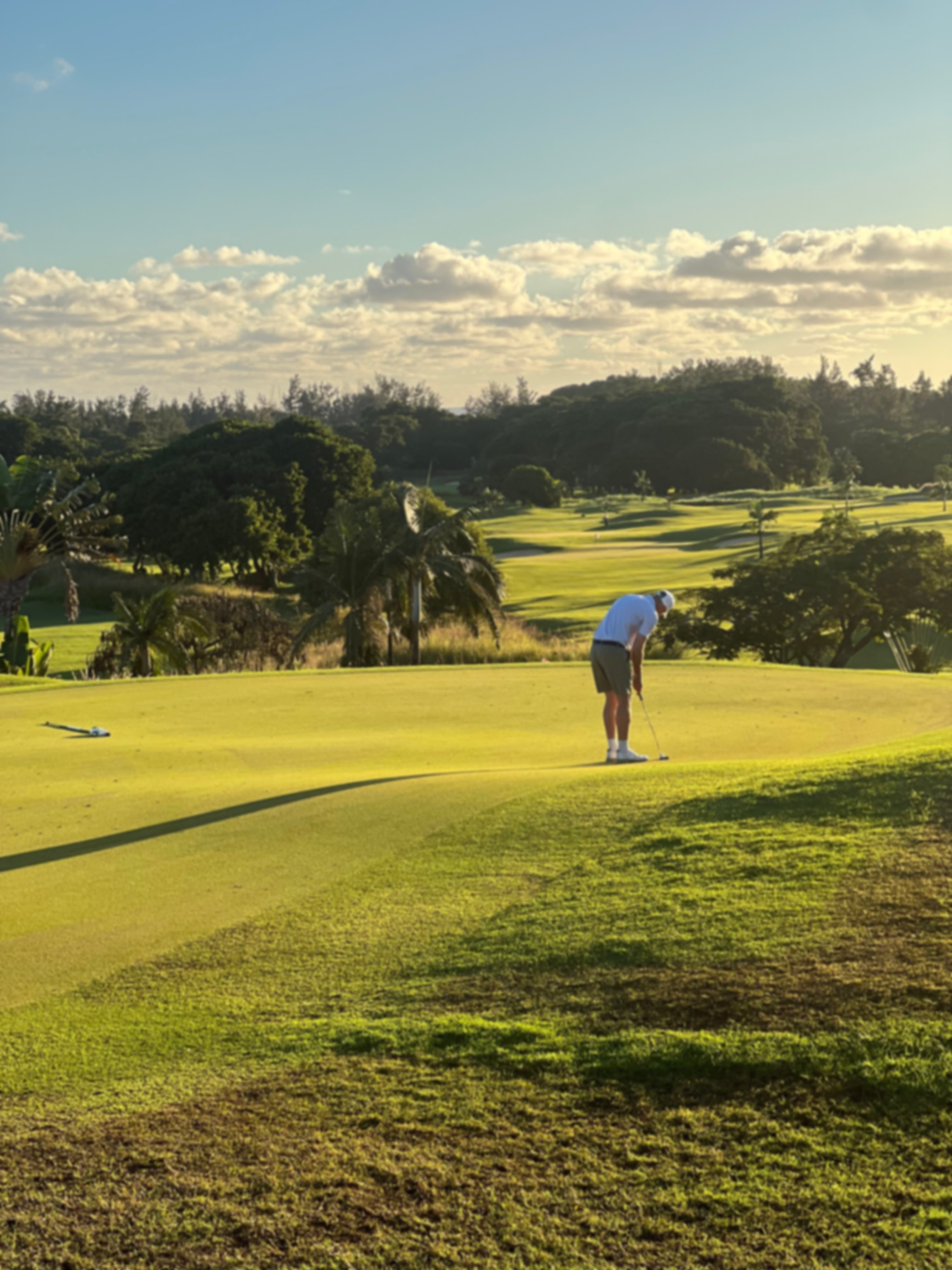 Golfer on a golf course under blue sky