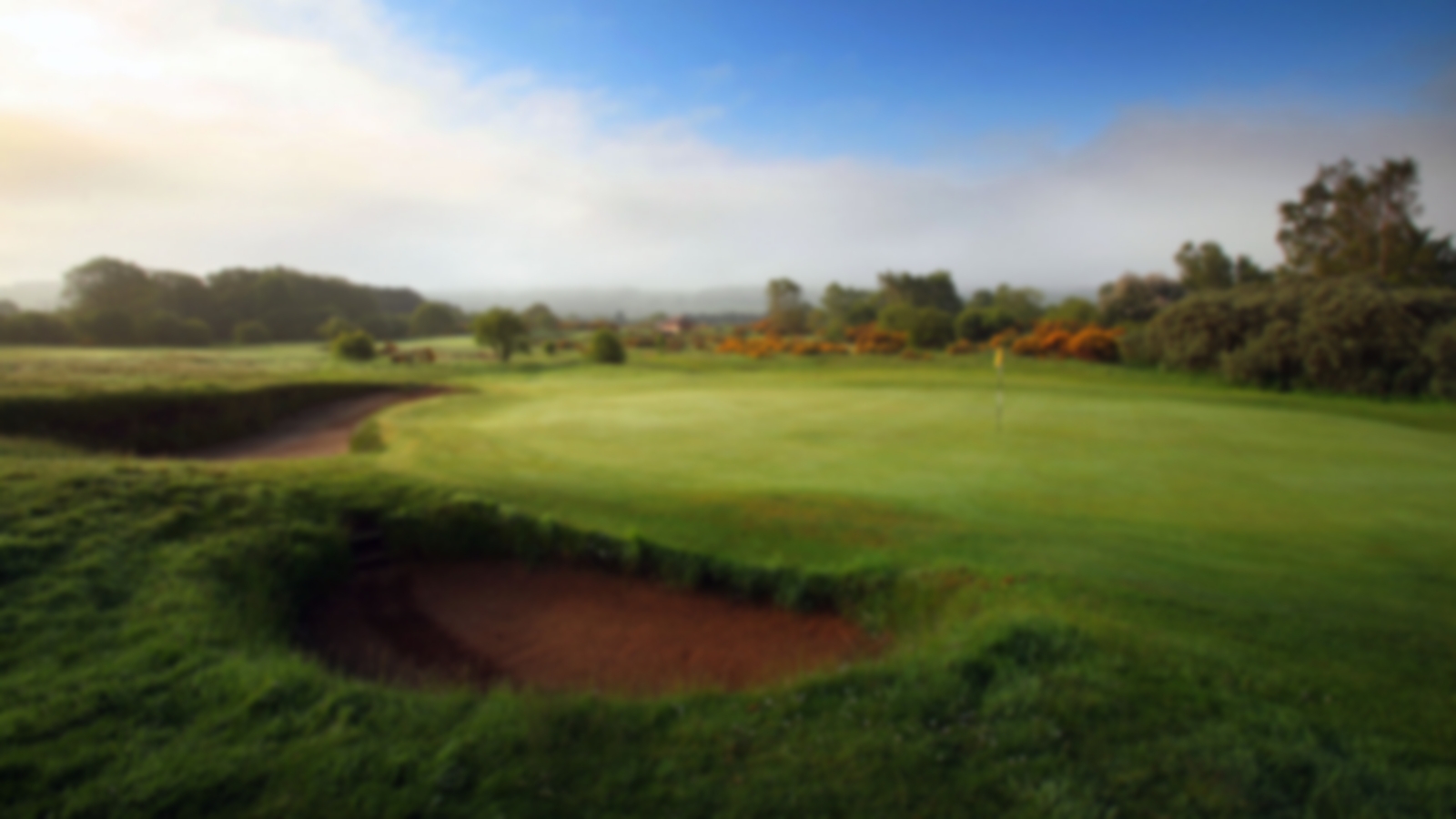 Pristine gree with blue skies and deep bunkers