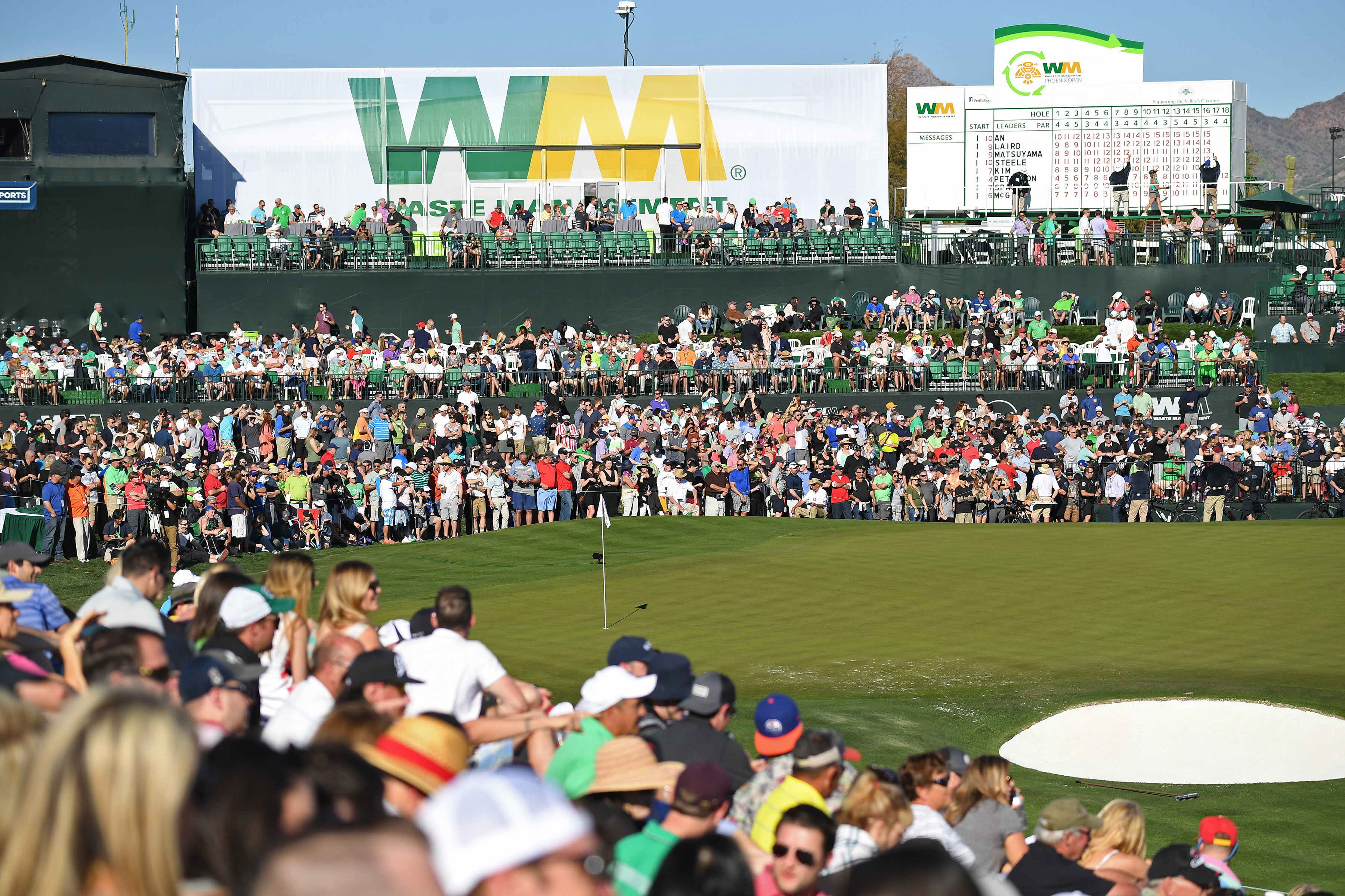 Spectators surround the green and get close to the action at the WM Phoenix Open