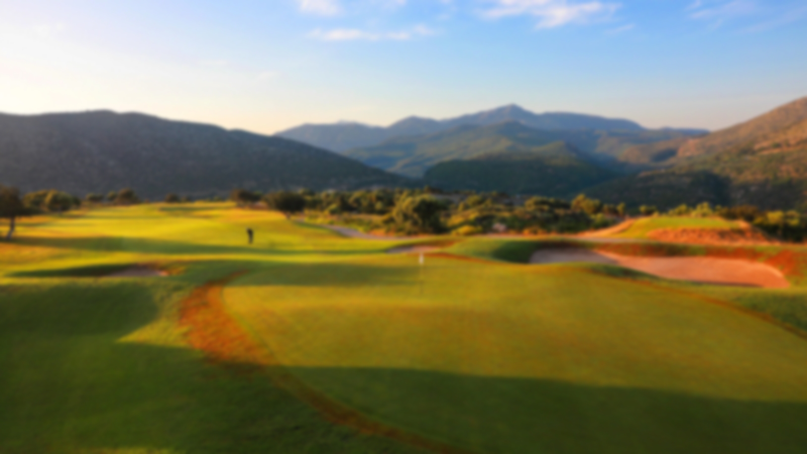 Crete Golf Club green with a beautiful sunset over the backdrop of the surrounding mountains.