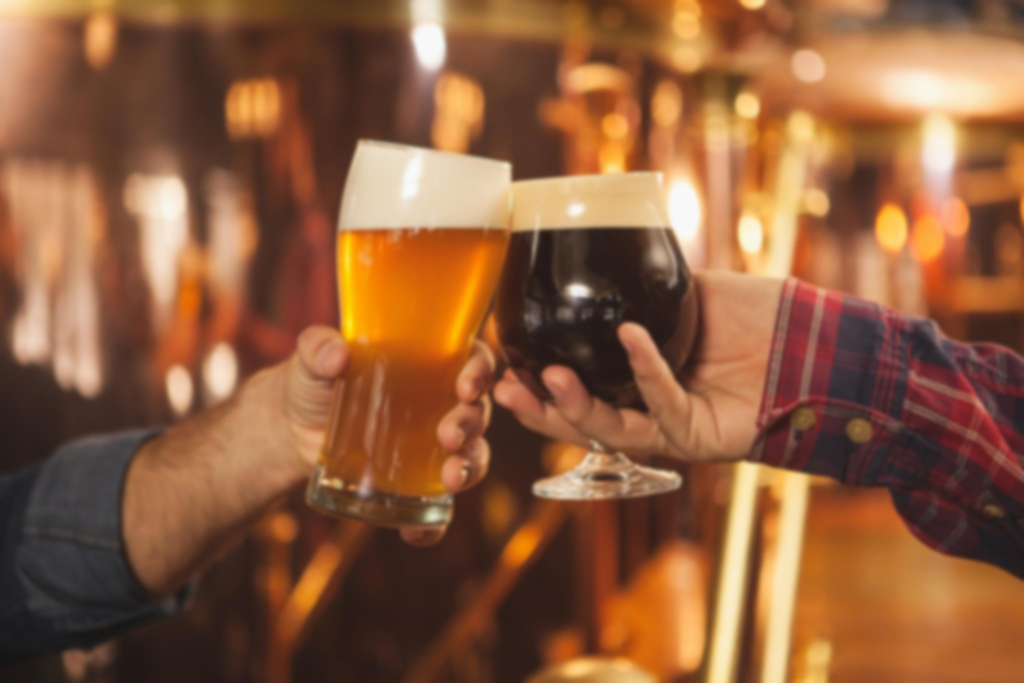 Two people holding drinks clinking their glasses