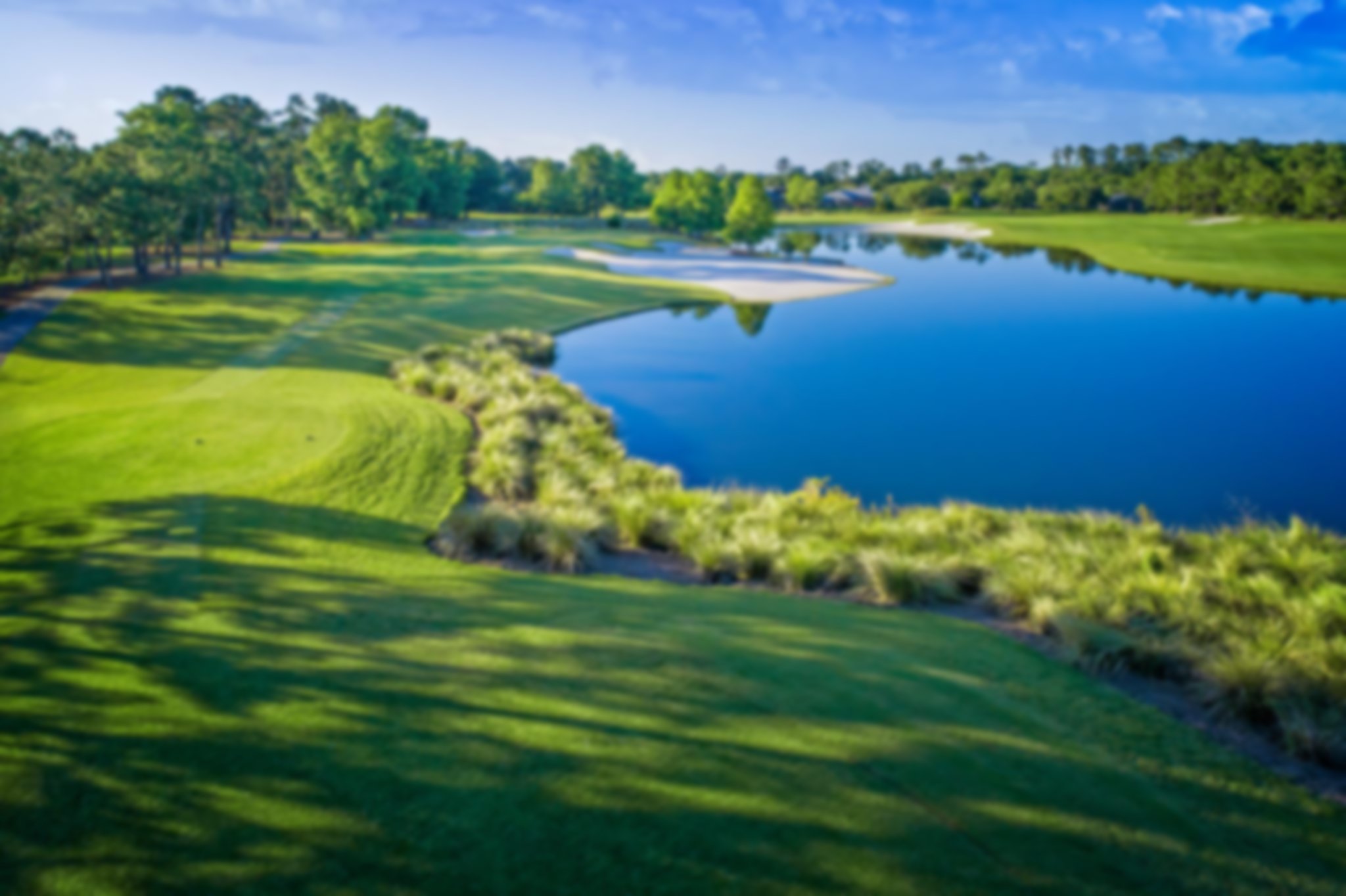 Fantastic shot of the fairway with a blue lake tot he right of the whole at King and Bear golf club 