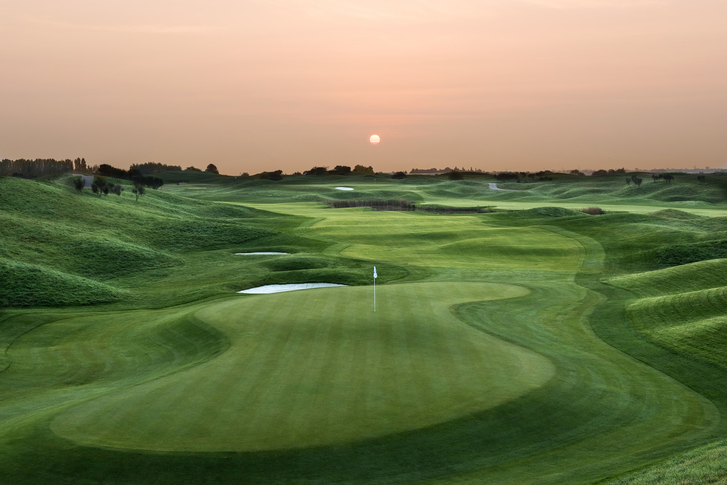 Sunset at Le Golf National L'Albatros page, with beautifully manicured fairways and water fronted green.