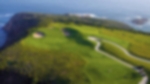 Clifftop hole, aerial view of the green with the cliffs and sea in the background.