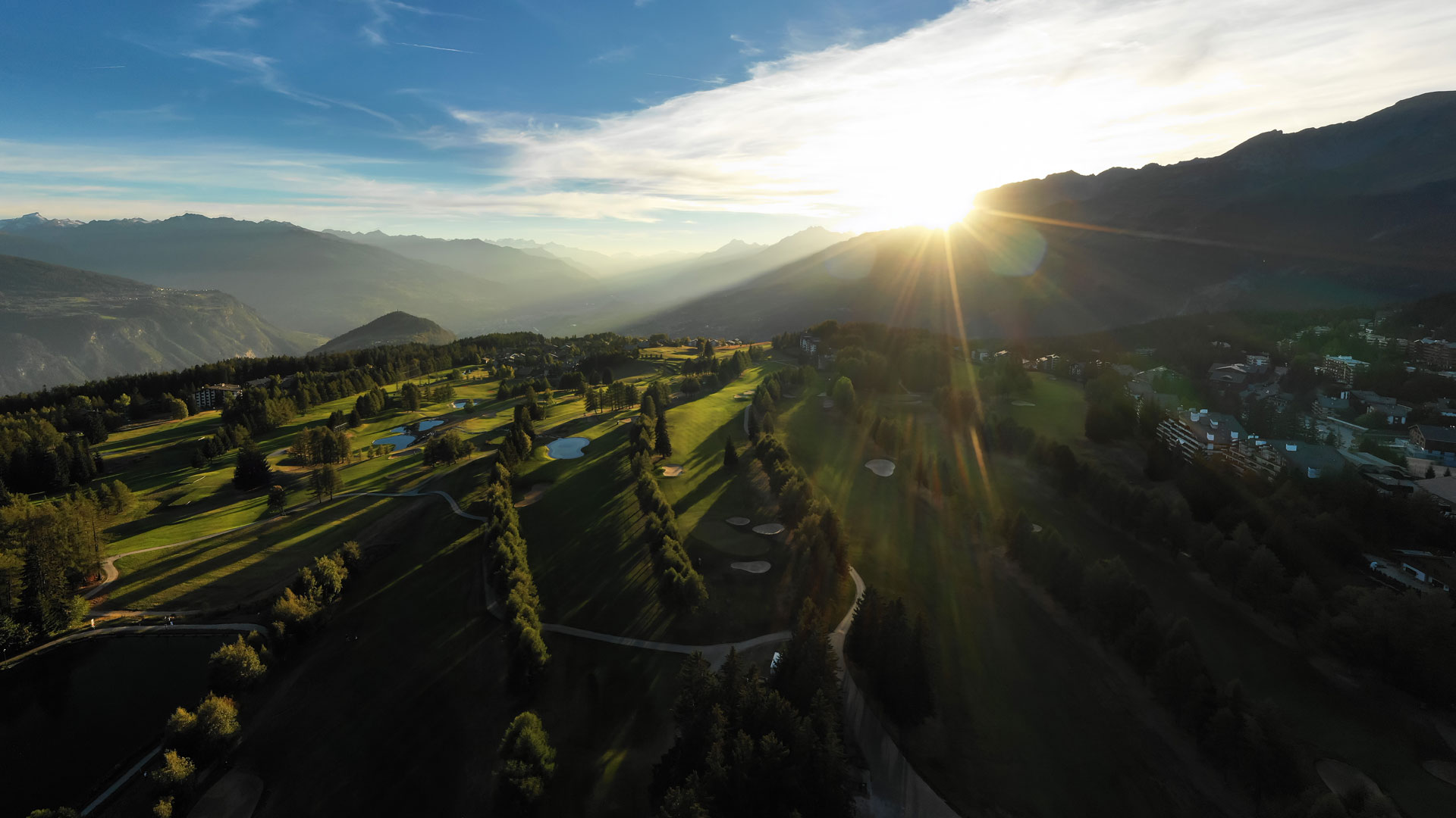 Beautiful swiss mountain with sun coming through the clouds and blue skies