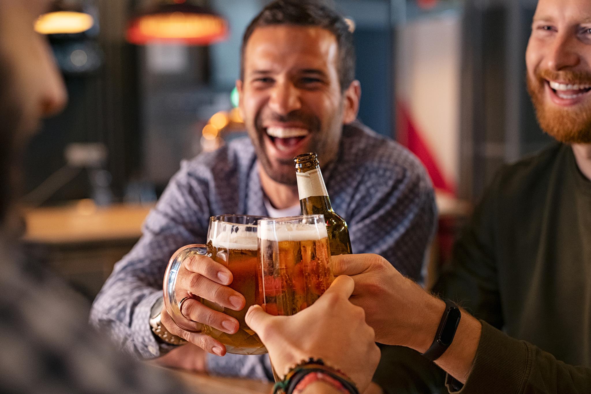 Three men holding beer glasses