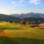 Crete Golf Club green with a beautiful sunset over the backdrop of the surrounding mountains.