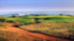 Orange sand with lush green fairways and greens, overlooking the sea.