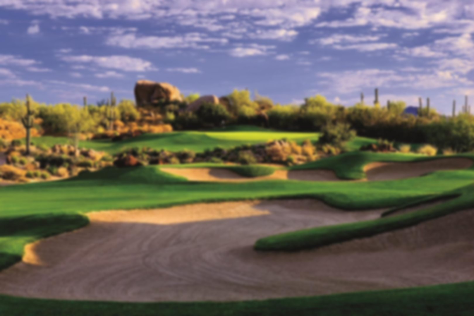 Bunkers sit in the fairway as you look up to an elevated green 