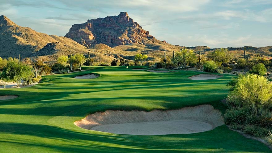 Large bunkers guard the stunning green fairway towards the green. Mountains act as the beautiful backdrop for this hole.