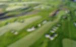 An aerial view of a golf course with meticulously maintained fairways and bunkers, showing off the lush greenery of the course.