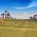 Golfer playing on the beautiful fairway at Assoufid, hitting their approach shot into the mountain backdrop