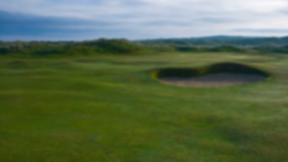 Undulating fairways at Ballyliffin Golf Club with bunker fronting the manicured green.