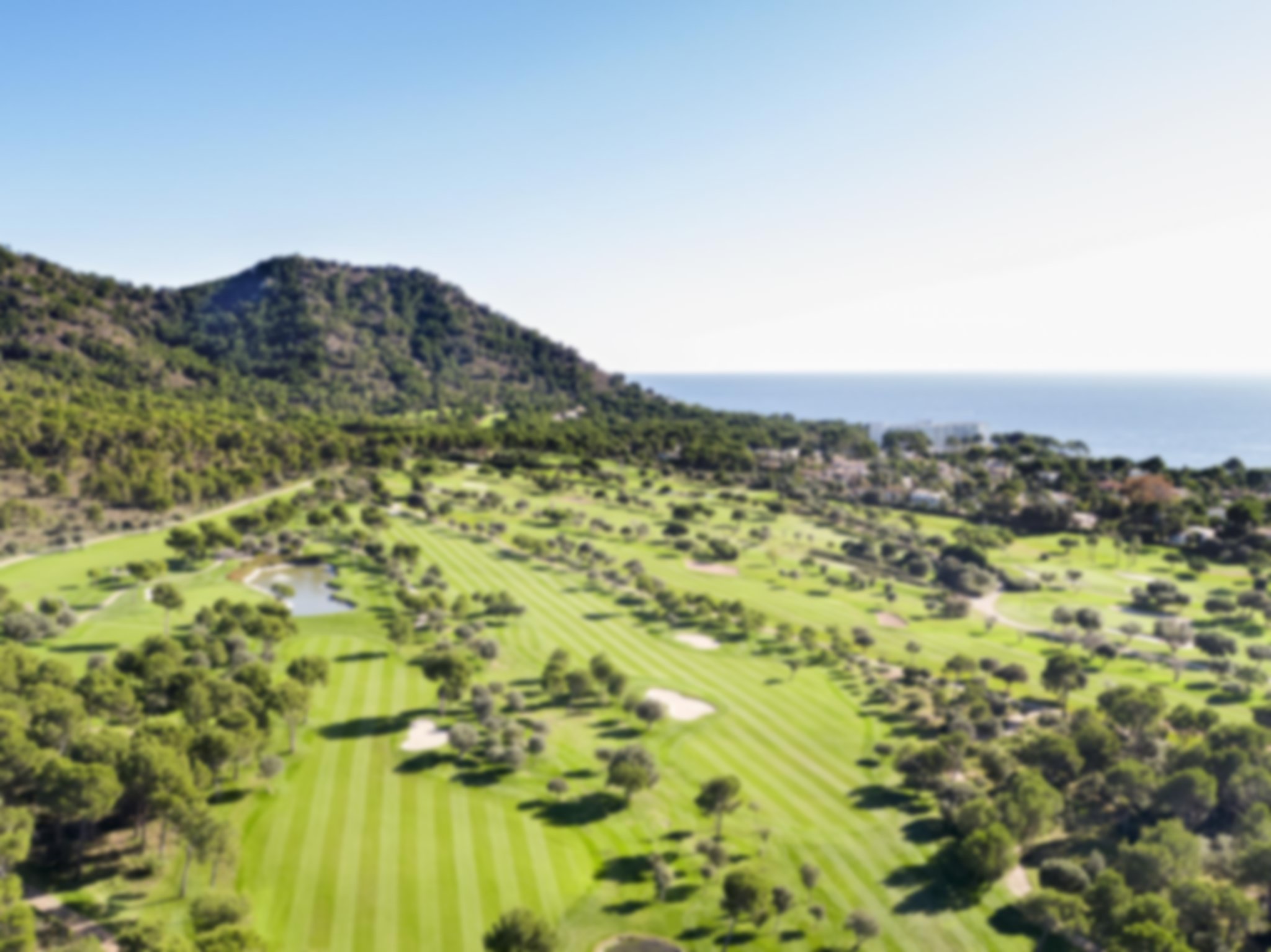 Aerial shot of Club de Golf de Son Servera golf course with mountains and sea view