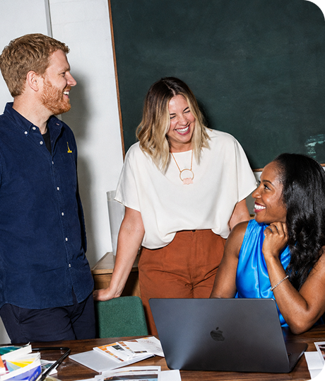 Three coworkers collaborating around a laptop